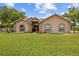 Well-maintained single-Gathering home featuring a lush green lawn and beautiful landscaping at 7932 Ridge Pointe W Dr, Lakeland, FL 33810