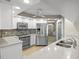 Bright kitchen featuring stainless steel appliances, white cabinetry, and quartz countertops at 7932 Ridge Pointe W Dr, Lakeland, FL 33810
