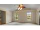 The carpeted main bedroom has a ceiling fan, two windows, and striped wallpaper at 7932 Ridge Pointe W Dr, Lakeland, FL 33810