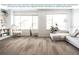 Spacious living room featuring vinyl plank flooring, large windows, and stylish decor at 797 Cypress Creek Run, St Cloud, FL 34771