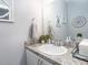 Well-lit powder room with white sink, gray marble countertop, modern decor, and neutral wall color at 867 Cypress Creek Run, St Cloud, FL 34771
