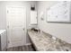 Laundry room with a long countertop, white cabinets and door, and a mounted calendar at 867 Cypress Creek Run, St Cloud, FL 34771