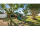 Spacious backyard featuring a wooden playset, lush lawn, and mature trees for Gathering fun at 8904 Pebblebrooke Dr, Lakeland, FL 33810
