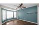 Bright bedroom featuring a ceiling fan, bay window, and a fresh blue accent wall at 8904 Pebblebrooke Dr, Lakeland, FL 33810