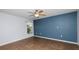 Cozy bedroom with ceiling fan, tile floors, and blue accent wall at 8904 Pebblebrooke Dr, Lakeland, FL 33810