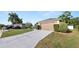 Driveway view of a house with a two-car garage, landscaped bushes, and green grass at 8904 Pebblebrooke Dr, Lakeland, FL 33810