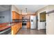 Well-lit kitchen features stainless steel appliances, brown cabinets, and granite countertops at 8904 Pebblebrooke Dr, Lakeland, FL 33810
