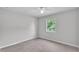 This bedroom features neutral carpet, neutral walls, a ceiling fan and a window at 1017 Fleming Ave, Lakeland, FL 33815