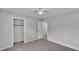 This bedroom features neutral carpet, a ceiling fan, and a spacious closet at 1017 Fleming Ave, Lakeland, FL 33815