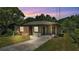 Charming single-story brick home with a covered carport and a well-maintained front yard at dusk at 1017 Fleming Ave, Lakeland, FL 33815