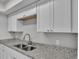 This kitchen features a stainless steel sink, granite countertops and bright white cabinets at 1017 Fleming Ave, Lakeland, FL 33815