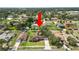 Aerial view showing the house, mature trees, and lush landscaping in the front and back yards at 111 E Orange St, Davenport, FL 33837