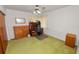 Bedroom setup with a desk, storage, and green carpeting at 111 E Orange St, Davenport, FL 33837