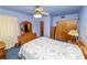 Cozy bedroom with floral bedding, wood furnishings, and a ceiling fan fixture at 111 E Orange St, Davenport, FL 33837