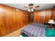 Shared bedroom with wood paneling, two beds, and overhead fan at 111 E Orange St, Davenport, FL 33837