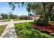 Charming single-story brick home with manicured lawn, mature shrubs, and an attached two-car garage at 111 E Orange St, Davenport, FL 33837