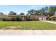Charming single-story brick home featuring a well-maintained front lawn and an attached two-car garage at 111 E Orange St, Davenport, FL 33837