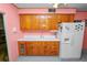 Retro kitchen with wood cabinets, a white refrigerator, and plenty of counter space, all in a bright, vintage style at 111 E Orange St, Davenport, FL 33837