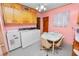 Kitchen area with white appliances, wood cabinets, and a breakfast table, blending functionality with vintage charm at 111 E Orange St, Davenport, FL 33837