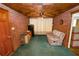 Unique den with brick walls, wood ceiling, and green carpet offers a cozy space for relaxing at 111 E Orange St, Davenport, FL 33837