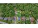 Overhead view of the property showing a home with a gray roof nestled in a lush, green, wooded neighborhood at 113 Patrick Henry Rd, Bartow, FL 33830