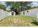 View of the backyard with white fence, shed and lots of green foliage at 113 Patrick Henry Rd, Bartow, FL 33830