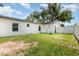 Back of house with grass, partial fence and foliage at 113 Patrick Henry Rd, Bartow, FL 33830