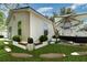 Exterior of the home features landscaped yard, privacy fence, stone pathways and patio area with umbrella and outdoor furniture at 113 Patrick Henry Rd, Bartow, FL 33830