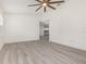 A bright bedroom showcasing the neutral color scheme, ceiling fan, and wood-look flooring at 113 Patrick Henry Rd, Bartow, FL 33830