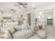 Staged primary bedroom with neutral decor, wood-look floors, ceiling fan, and a sitting area at 113 Patrick Henry Rd, Bartow, FL 33830