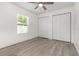 This bedroom features wood-look flooring and ample closet space, along with a bright window at 113 Patrick Henry Rd, Bartow, FL 33830