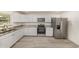 Kitchen features white cabinets, gray marble countertops, stainless steel appliances, and light gray flooring at 113 Patrick Henry Rd, Bartow, FL 33830