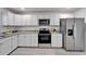 Updated kitchen with white cabinets, stainless steel appliances, and gray marbled countertops at 113 Patrick Henry Rd, Bartow, FL 33830