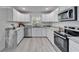 Kitchen featuring stainless appliances, white cabinetry, gray countertops and luxury vinyl floors at 113 Patrick Henry Rd, Bartow, FL 33830