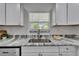 Kitchen sink with a view, stainless faucet, white cabinets, and grey countertops at 113 Patrick Henry Rd, Bartow, FL 33830