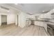 Bright kitchen boasts white cabinets, gray marble countertops, stainless steel appliances, and durable light gray flooring at 113 Patrick Henry Rd, Bartow, FL 33830