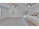 Spacious main bedroom with backyard view through sliding doors, fan, and light neutral tones at 113 Patrick Henry Rd, Bartow, FL 33830