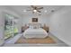Serene main bedroom featuring a tufted headboard, slider to the yard, and modern nightstands at 113 Patrick Henry Rd, Bartow, FL 33830