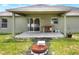 Covered back porch with sliding glass door, patio and fire pit offer a great outdoor living space at 1140 Stratton Ave, Groveland, FL 34736