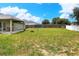 Large backyard featuring grass, a fire pit, and a covered patio, offers ample space for outdoor activities at 1140 Stratton Ave, Groveland, FL 34736