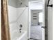 Tiled tub and shower combination with curtain; bathroom is freshly updated at 1140 Stratton Ave, Groveland, FL 34736