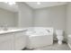 Bright bathroom boasts a tiled corner tub, tile floors, and a toilet at 1140 Stratton Ave, Groveland, FL 34736