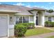 Front of house featuring a two-car garage, green lawn and arched entryway, and white window frames at 1140 Stratton Ave, Groveland, FL 34736