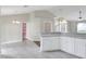Kitchen area featuring tile floors, white cabinets, and a dining nook next to a doorway to the pantry at 1140 Stratton Ave, Groveland, FL 34736