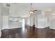 Open-concept living area with hardwood floors seamlessly connects to a kitchen with white cabinets at 1140 Stratton Ave, Groveland, FL 34736