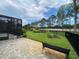 Private backyard boasts a lovely brick patio, mature trees, and black fence at 1167 Motorcoach Dr, Polk City, FL 33868