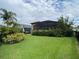 Well-maintained backyard with green lawn, mature plants and an enclosed lanai at 1167 Motorcoach Dr, Polk City, FL 33868