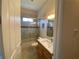 Bathroom featuring a granite countertop vanity, framed mirror, and tiled shower at 1167 Motorcoach Dr, Polk City, FL 33868