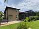 Exterior elevation features a patio, green lawn and mature landscaping at 1167 Motorcoach Dr, Polk City, FL 33868