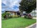 Beautifully landscaped front yard with lush green grass and mature trees surrounding a tan home at 1167 Motorcoach Dr, Polk City, FL 33868